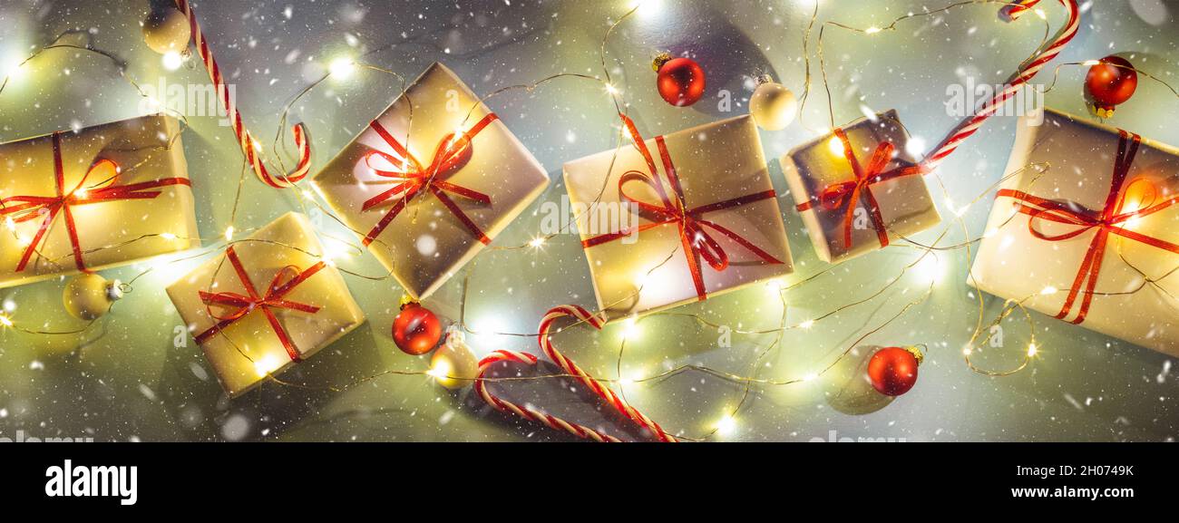 Banner with white Christmas gift boxes with garland lights and snow