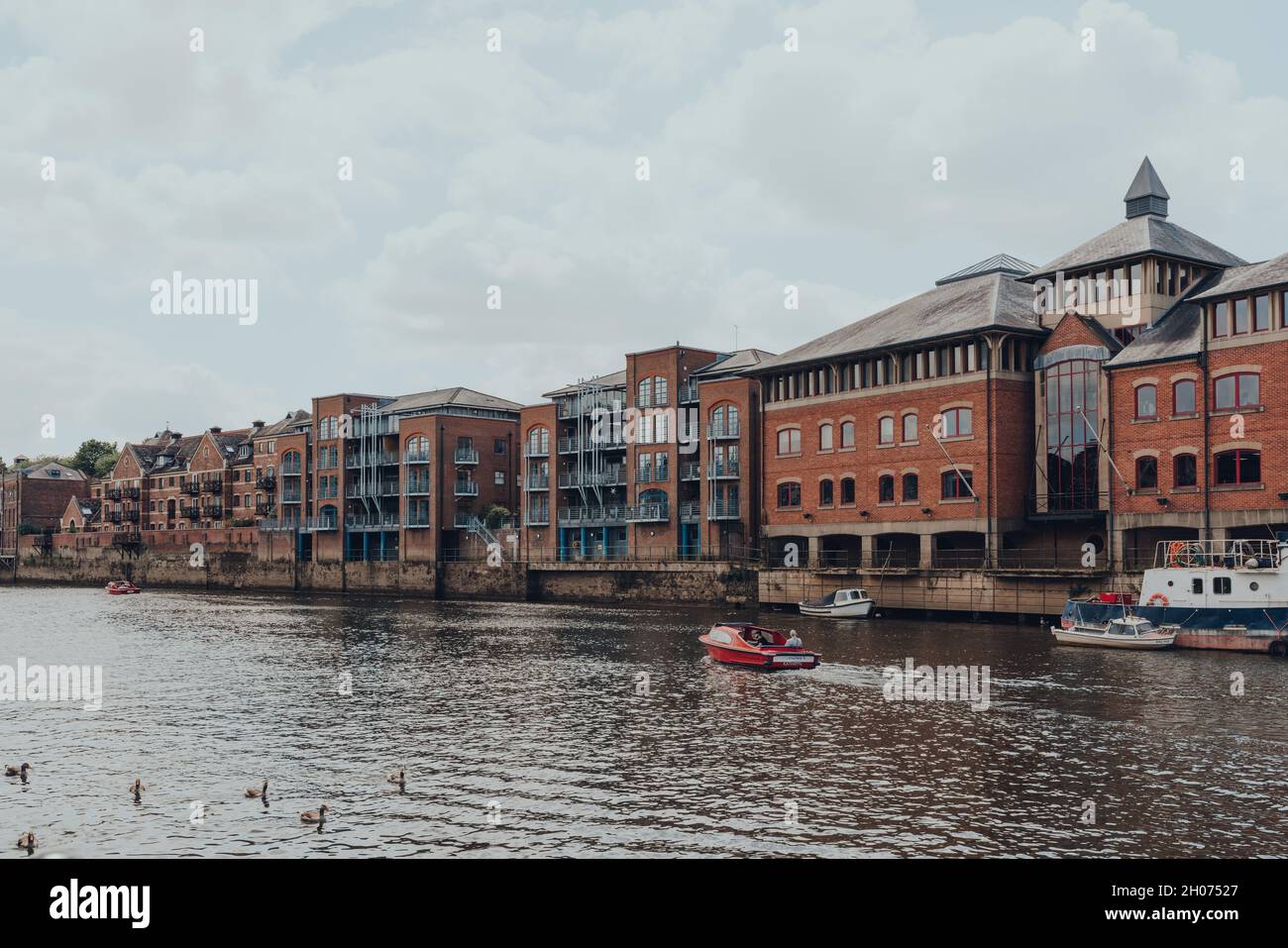 York, UK - June 22, 2021: Self-drive red hire boat on a River Ouse in York. Hire boats are a popular activity to explore the city founded by the ancie Stock Photo