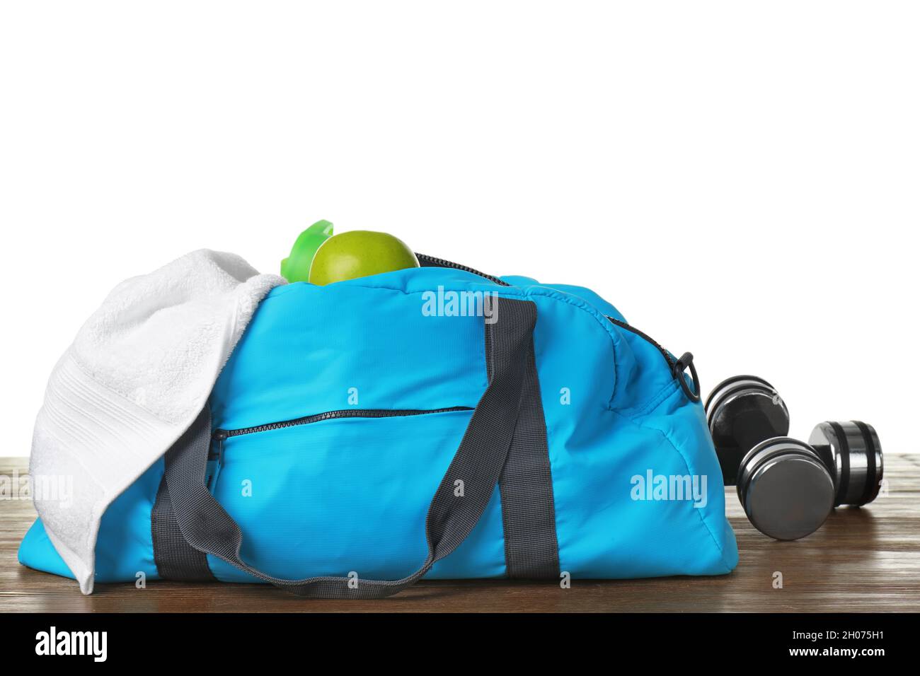 Sports bag and gym equipment on table against white background Stock ...