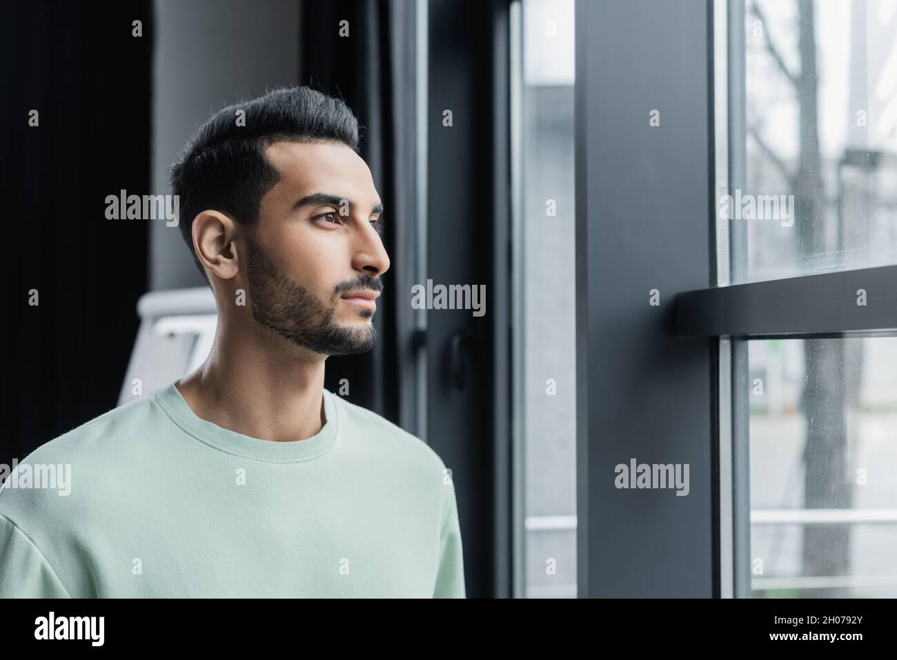 Young muslim businessman standing near window in office Stock Photo