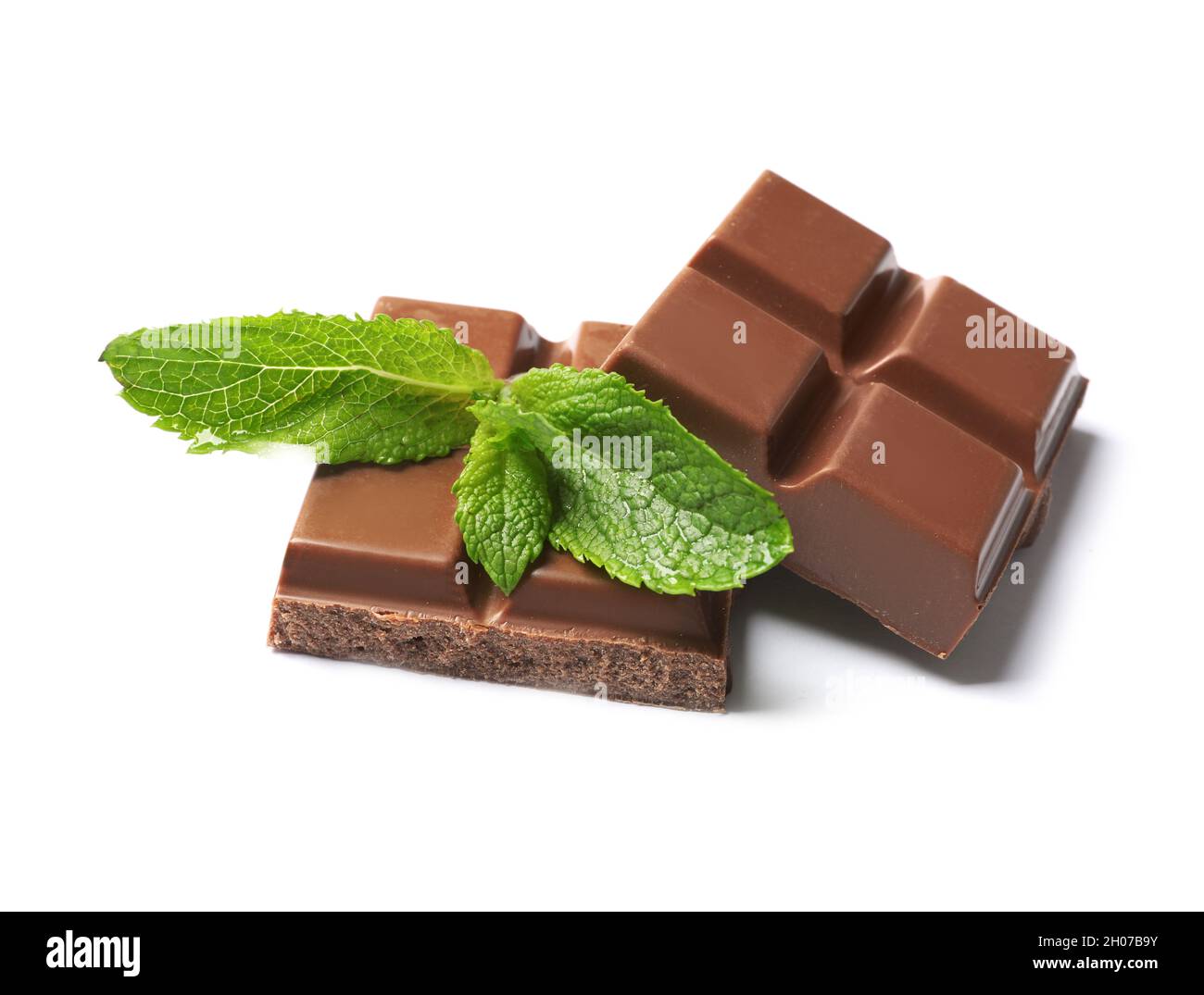 Pieces of milk chocolate with mint on white background Stock Photo - Alamy