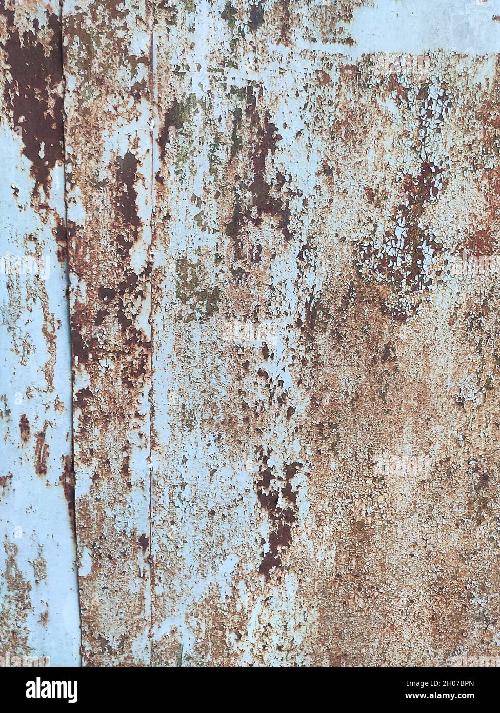 Corroded metal background. Rusted white painted metal wall. Rusty metal background with streaks of rust. Rust stains. The metal surface rusted spots. Stock Photo