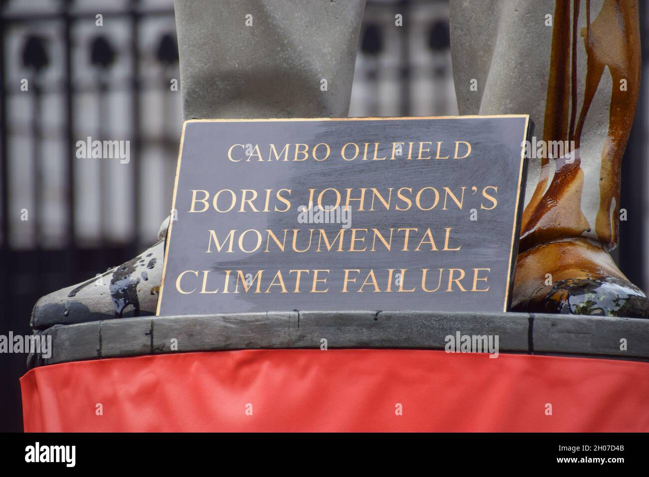 London, UK. 11th Oct, 2021. A sign which says 'Cambo Oil Field: Boris Johnson's Monumental Climate Failure' is seen at the foot of the statue of Boris Johnson splattered with fake oil, during the Stop Cambo protest.Greenpeace activists locked themselves to barrels and installed a large statue of Boris Johnson smeared in fake oil outside Downing Street, in protest against the Cambo oil field. Credit: SOPA Images Limited/Alamy Live News Stock Photo