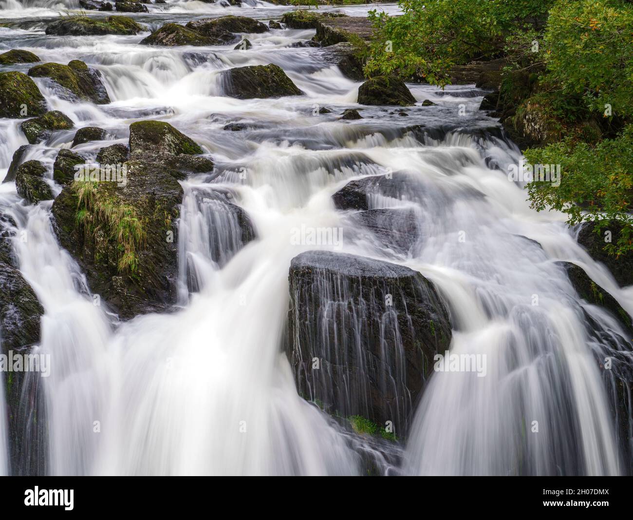 long exposure of white water cascading over the magnificent Rhaeadr Ewynnol Swallow Falls Waterfall, Betws-y-coed, Snowdonia National Park, Wales UK Stock Photo
