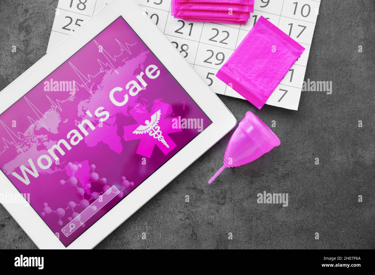 Flat lay composition with tablet, calendar and feminine hygiene items