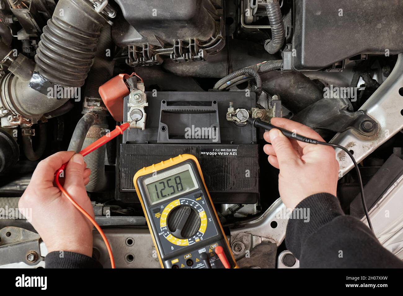 Checking car battery voltage on a car Stock Photo