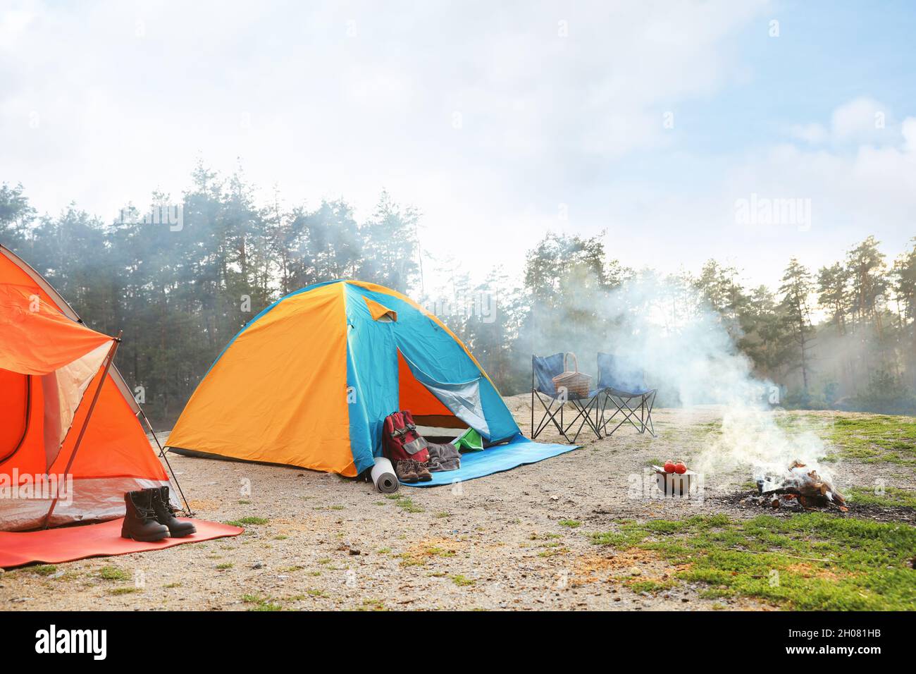 Camping tent and accessories in wilderness on summer day Stock Photo