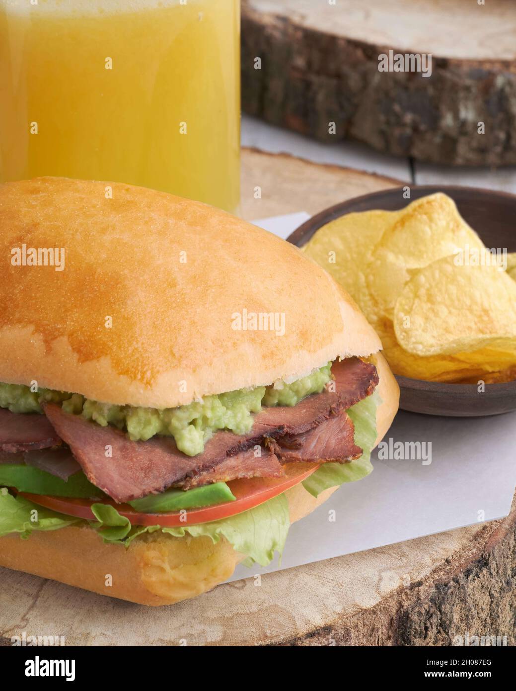 Roast beef sandwich with guacamole sauce served with orange juice and