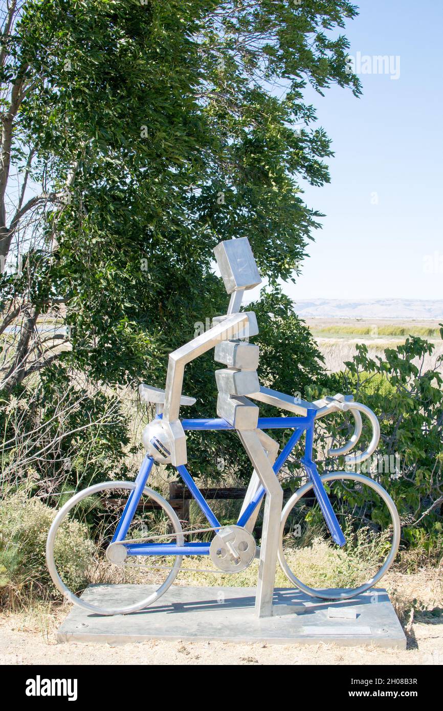 Stainless steel sculpture by James More: a cyclist on a blue road bike