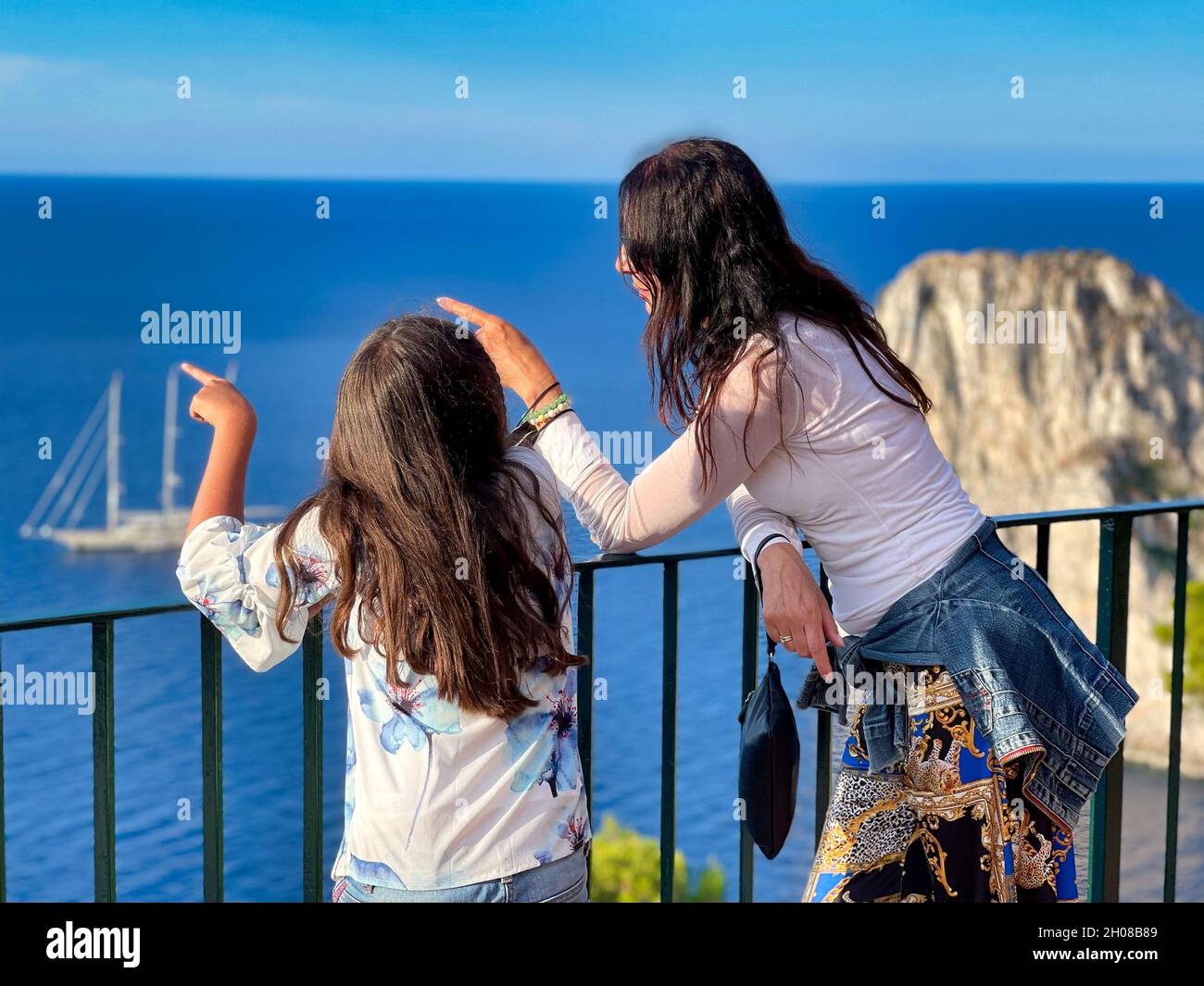 Mother and daughter looking at the sea from a viewpoint on a sunny day Stock Photo