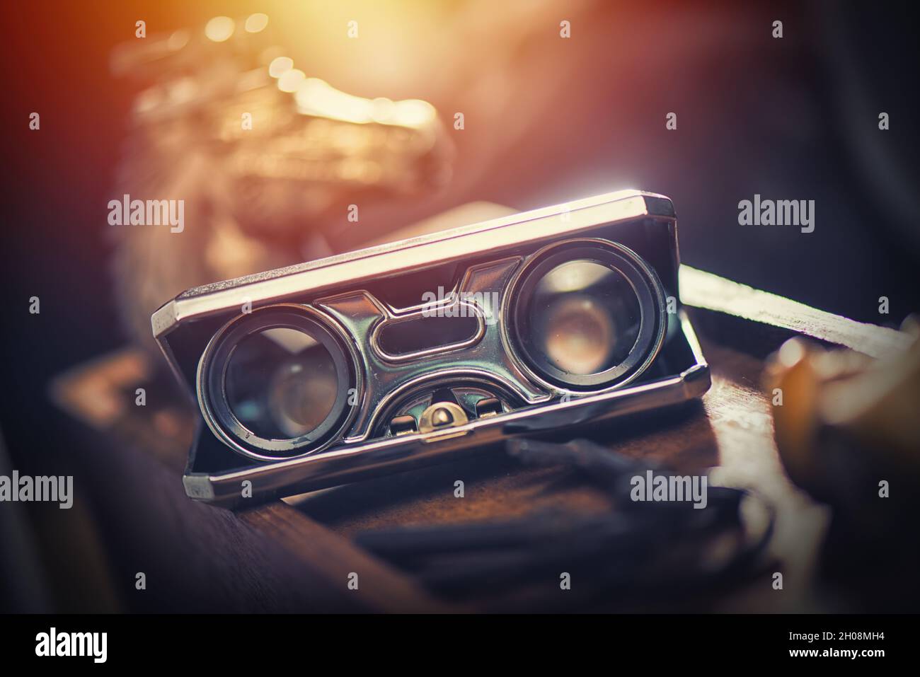Closeup vintage folding opera glasses. Old compact binoculars. Stock Photo