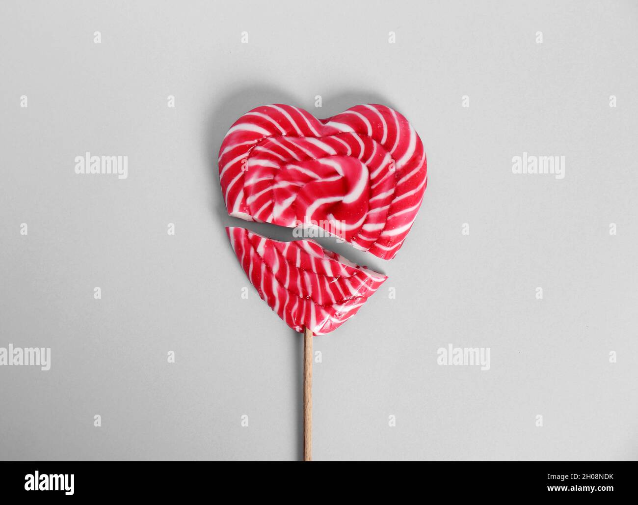 Broken heart shaped lollipop on white background, top view Stock Photo ...