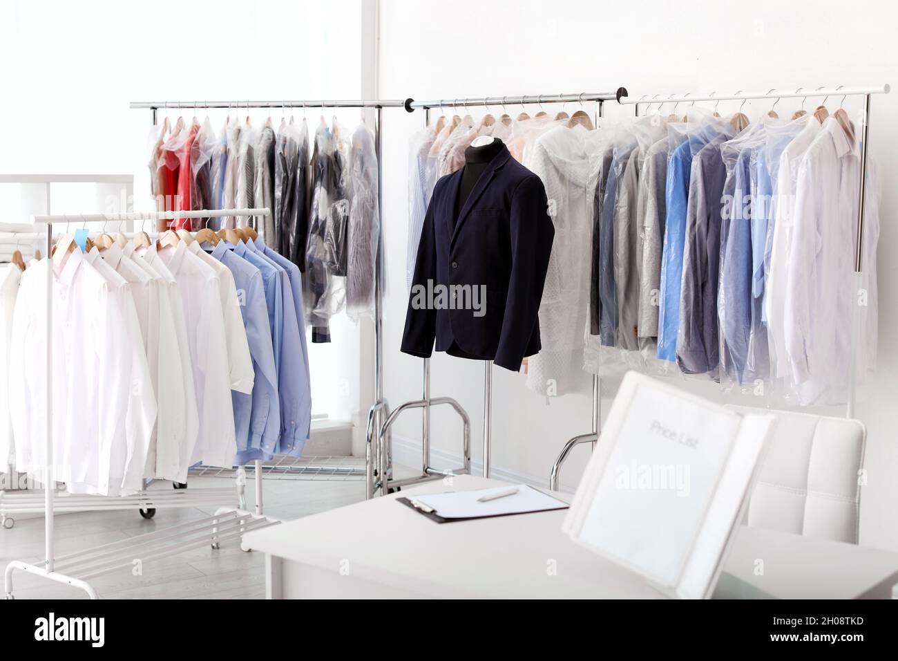 Drycleaner's interior with clothes on racks Stock Photo Alamy