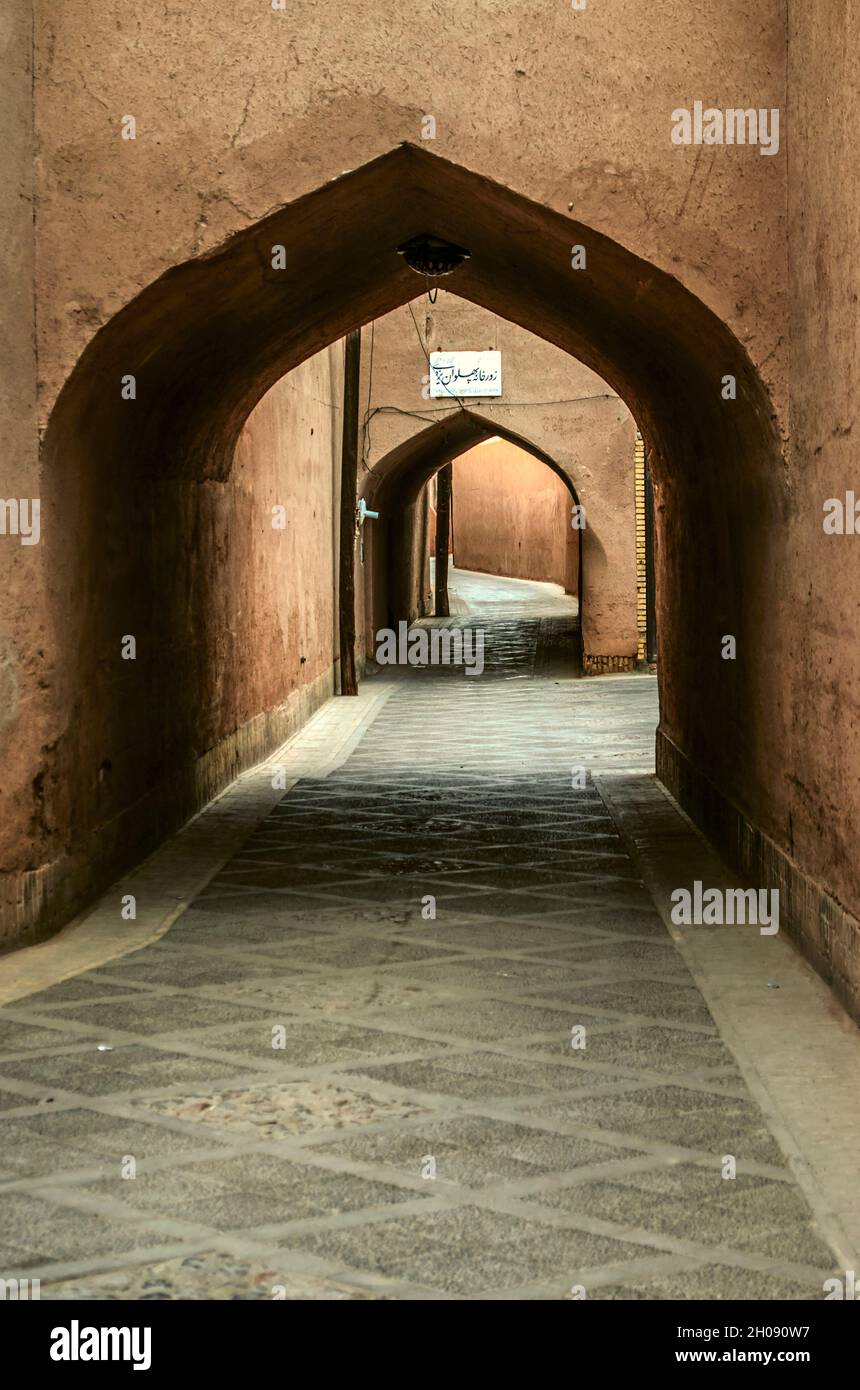 Yazd, Iran, February 19, 2021:Labyrinths, secret streets paved with stone tiles, among houses without windows, covered with adobe arches  in the ancie Stock Photo