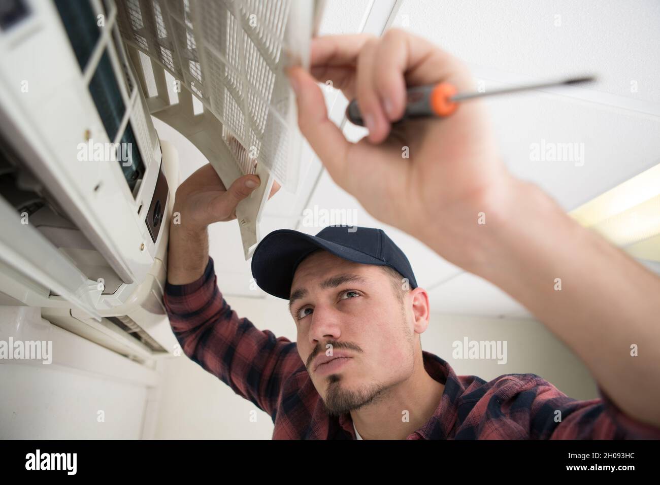 air conditioning repair man trying to repair the air conditioning Stock