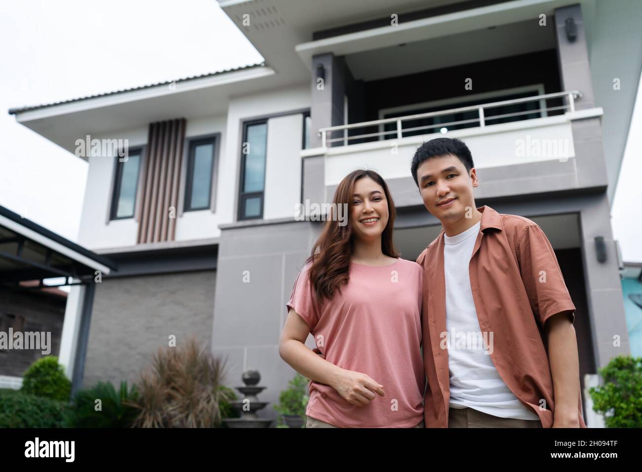happy young couple standing outside their house Stock Photo - Alamy