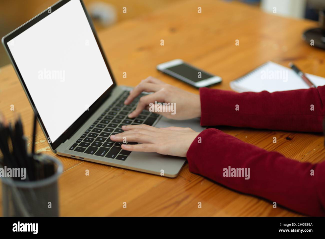 Cropped image of Smart business woman in red suit typing on laptop computer keyboard, working on laptop, laptop blank screen mockup. Stock Photo