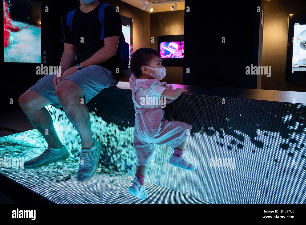 A young visitor climbs a tech installation artwork by multimedia artist  Victor Wong at the Digital Art Fair Asia in Hong Kong, China, on October  08, 2021. The fair showcases NFT Crypto