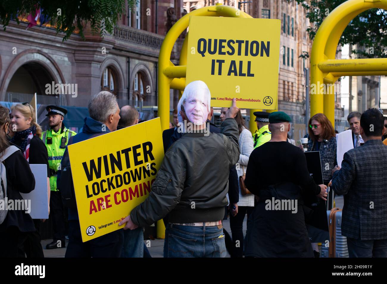 Tory Party Conference. Protester with banner text Question It All, Winter Lockdowns are Coming. Boris Johnson mask. Stock Photo