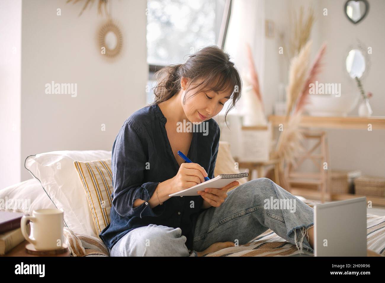 Focused young asian businesswoman write in notebook, learning, using ...