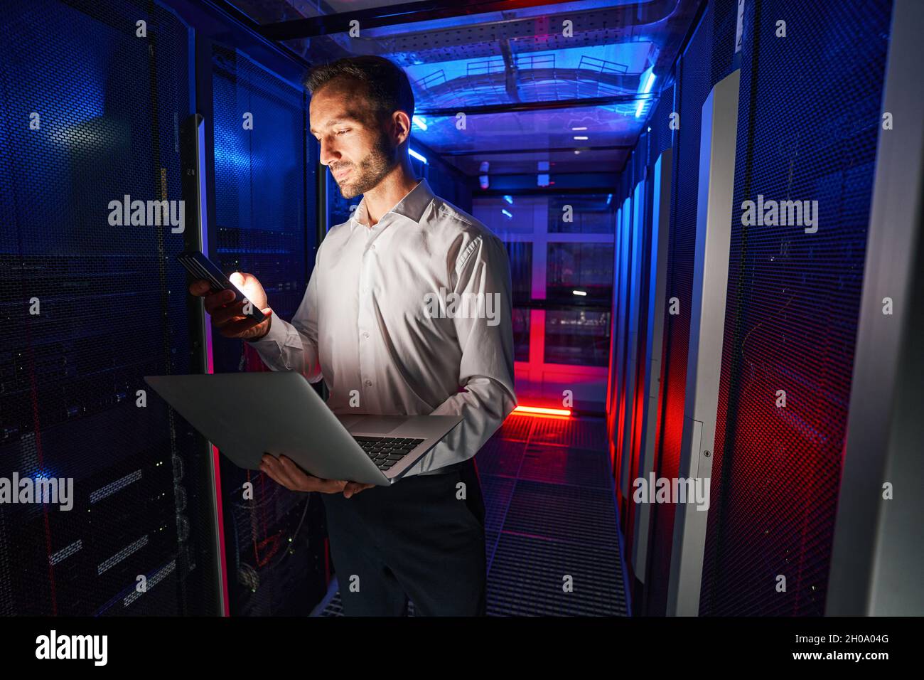 IT specialist using security appliance and laptop for server administration Stock Photo