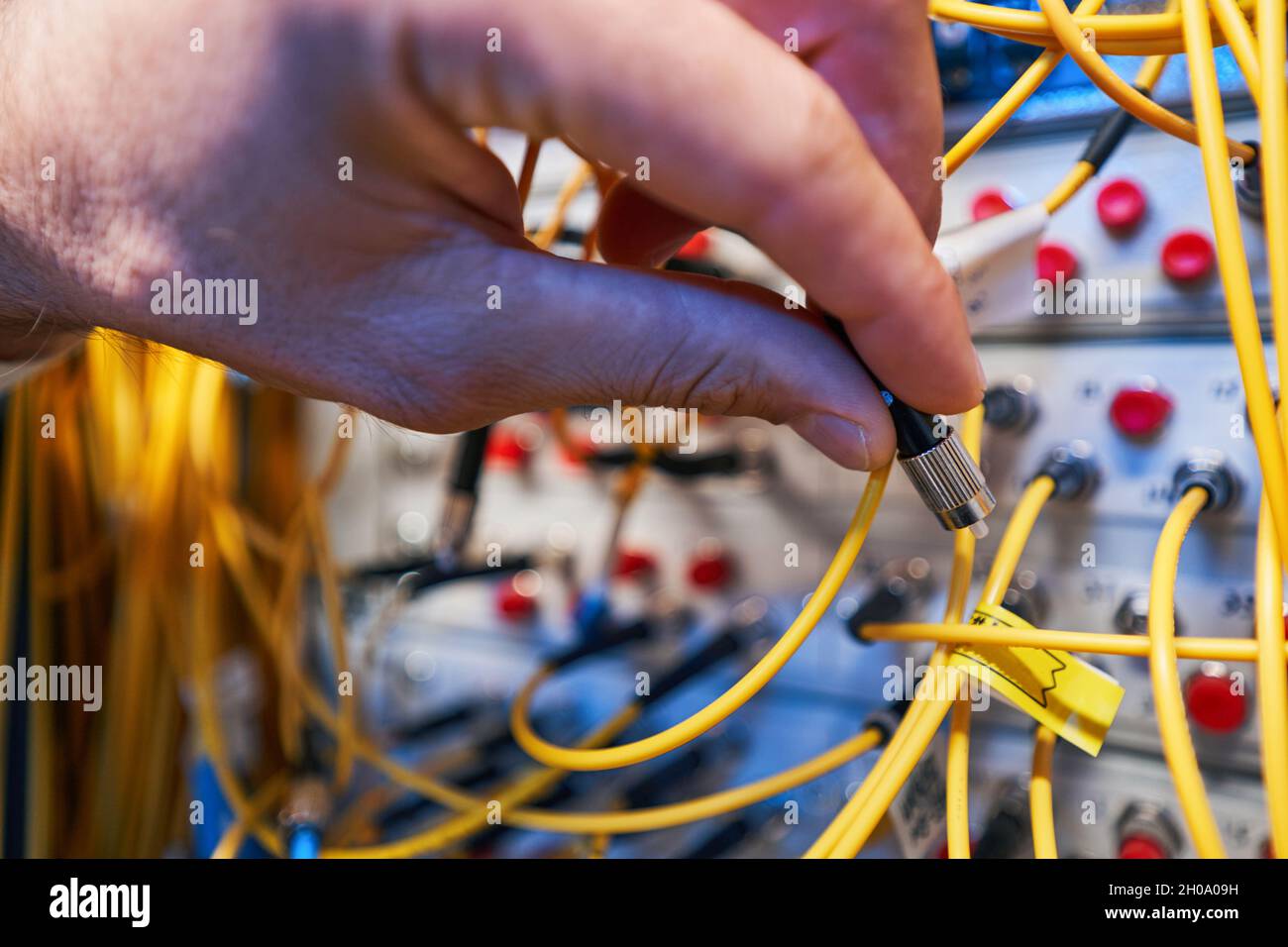 Network specialist putting it fiber-optic cable to patch panel Stock ...