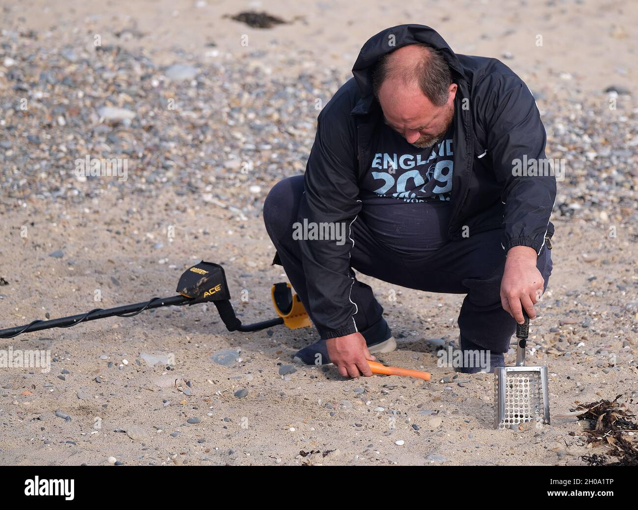 Metal detecting on the beach at a Uk east coast resort. Stock Photo