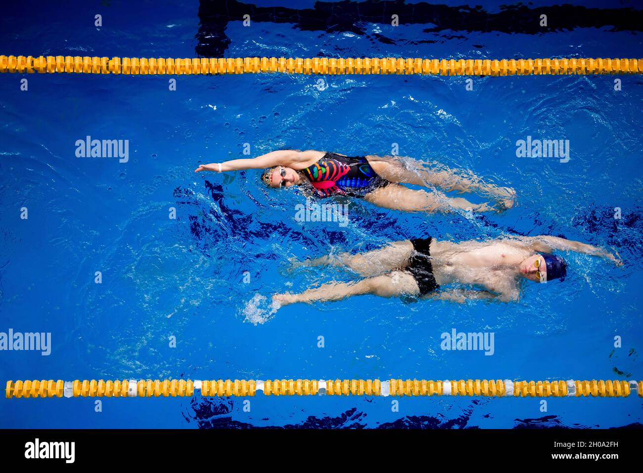 Training of professional swimmers. Athletes swim on their backs in the