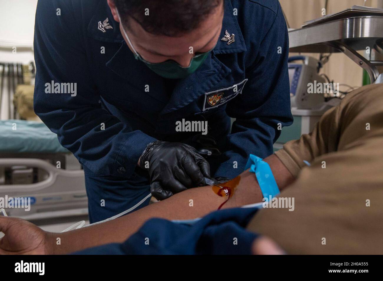 210105-N-JC800-1010     INDIAN OCEAN (Jan. 5, 2021) – U.S. Navy Hospital Corpsman 2nd Class Alfonso Chavez, assigned to medical department, draws blood from a patient in the medical ward aboard the amphibious transport dock ship USS Somerset (LPD 25). The Makin Island Amphibious Ready Group and the 15th Marine Expeditionary Unit are conducting operations in the 6th Fleet area of responsibility. Stock Photo