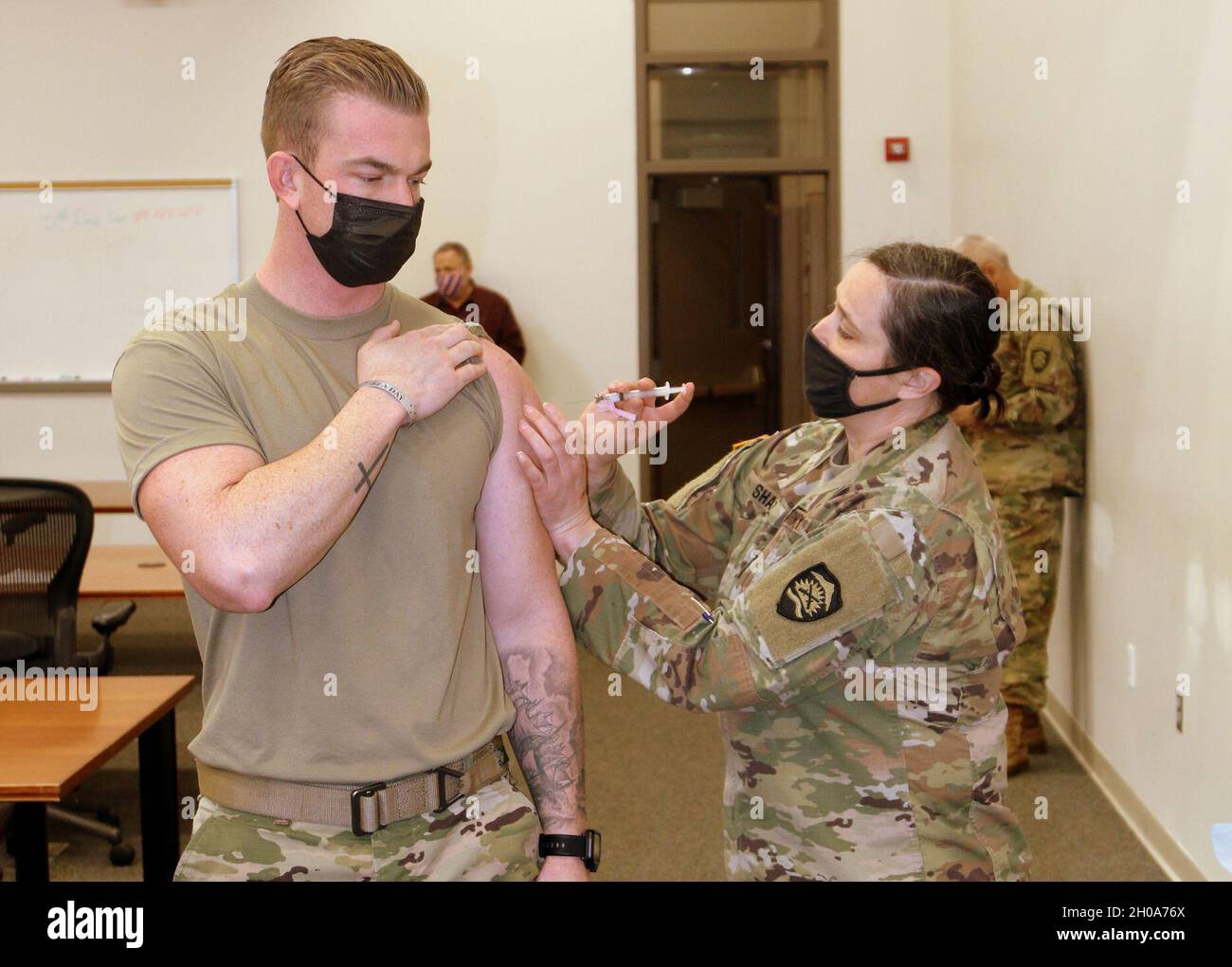 Oregon Army National Guard Capt. Christopher Killen, Civil Support Team, receives the COVID-19 vaccine from Maj. Naomi Shantz, Oregon Guard Medical Command, Jan. 5, 2021, Salem, Ore. Stock Photo