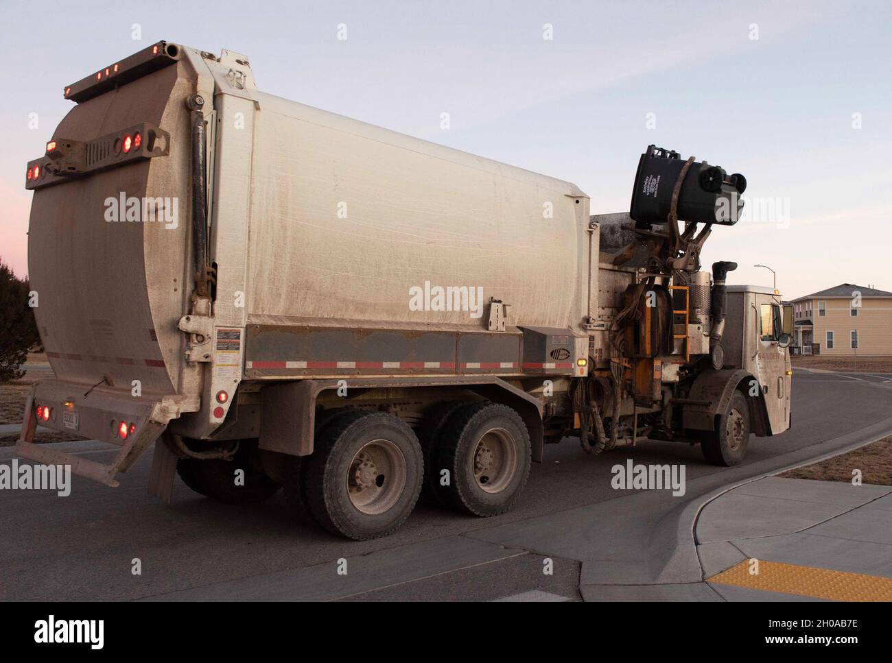 A garbage truck empties a trash can equipped with the Gust device at