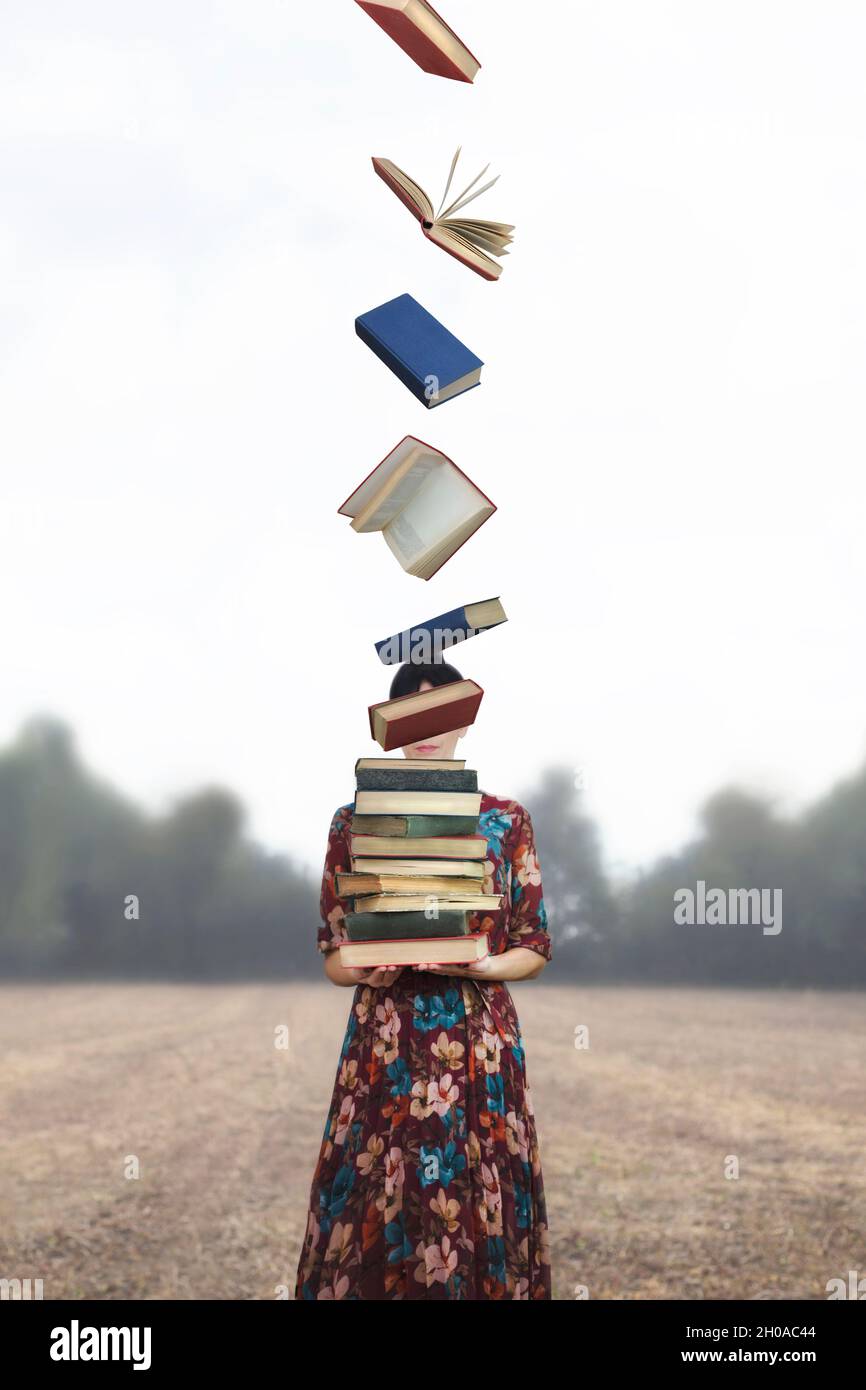 woman holds a stack of books that take flight free Stock Photo