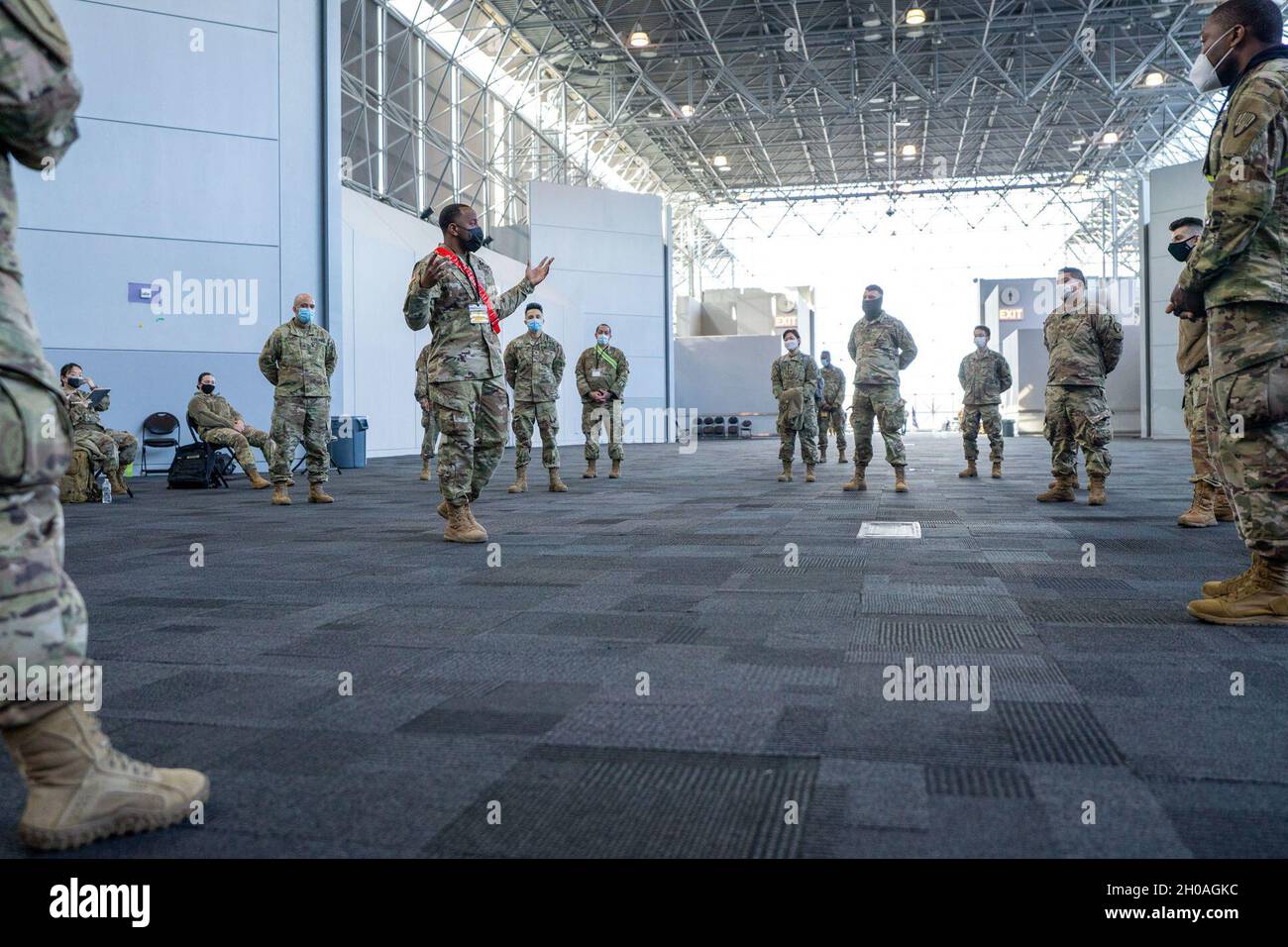 U.S. Army Staff Sgt. Terrance Locus, a heavy truck operations squad leader, assigned to the 719th Composite Truck Company, briefs Soldiers on safety protocols for mass COVID-19 vaccinations in support of the New York State Department of Health at the Javits Convention Center in Manhattan, New York, January 10, 2021. The National Guard has more than 350 Guardsmen and women deployed to the vaccination site to support access control, registration, and command post staffing for the site. The New York State Department of Health conducts vaccination efforts for essential workers and members of the c Stock Photo