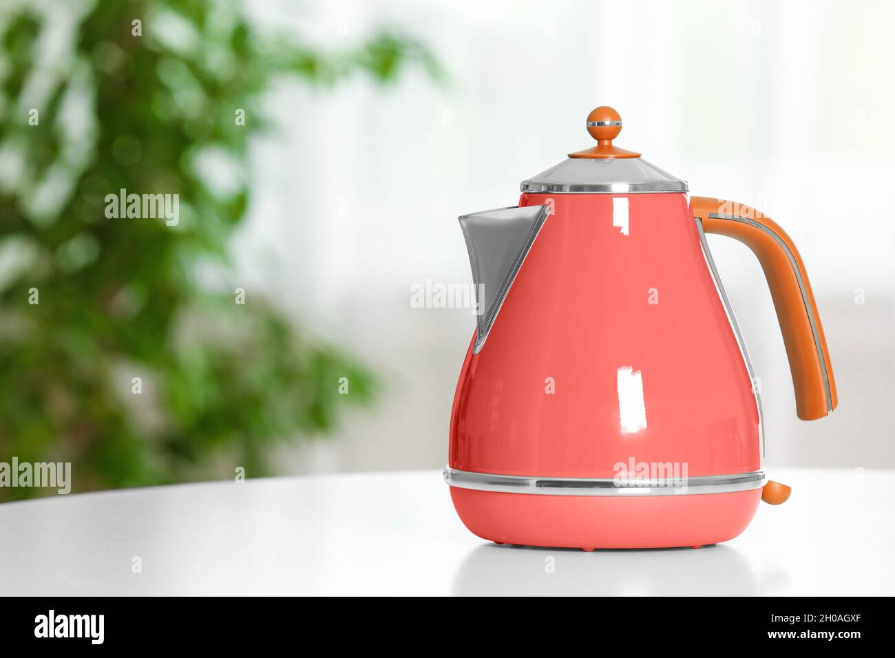 Stylish electrical kettle on table in room space for text. Design