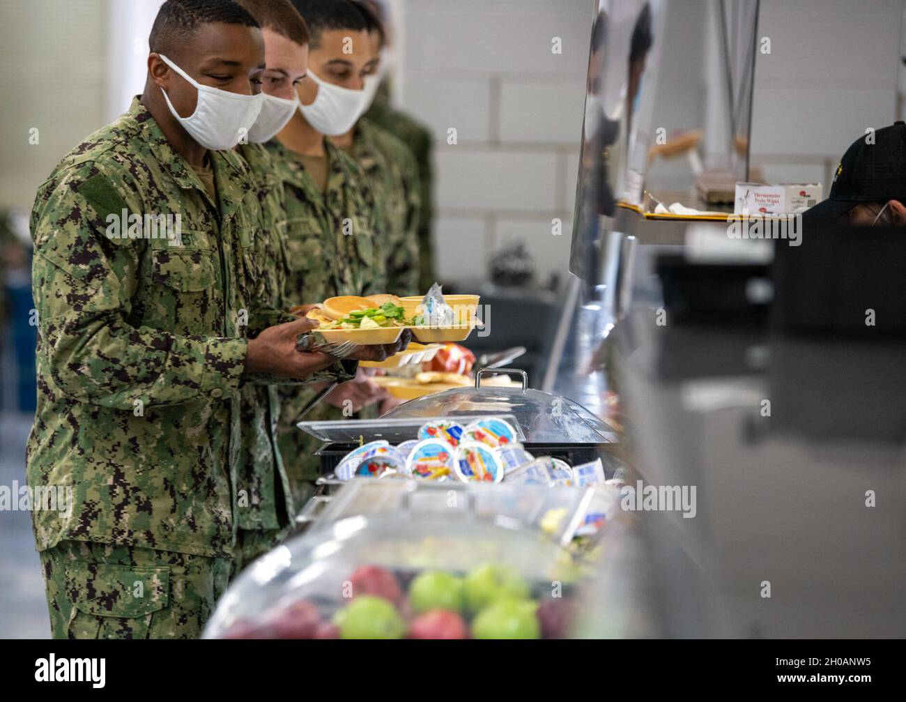 Recruits go through the chow line inside USS Pearl Harbor recruit