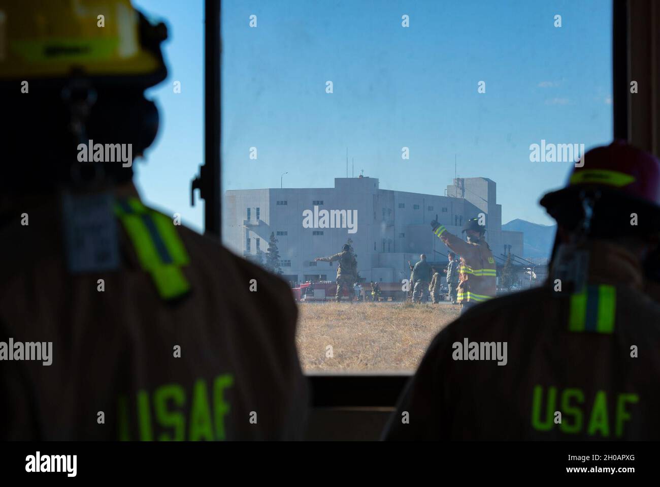 Fire fighters assigned to the 374th Civil Engineer Squadron fire department, are given hand signals while they operate the newly installed flightline BAK-12 barrier, aircraft arresting system (AAS) during its initial certification test at Yokota Air Base, Japan, Jan. 13, 2021. Hand signals are given to indicate the distance the barrier cable has to go to be considered completely retrieved. Ensuring the BAK-12 is fully functional through certification testing reenforces Yokota’s multi-capable presence in the Indo-Pacific region. Stock Photo