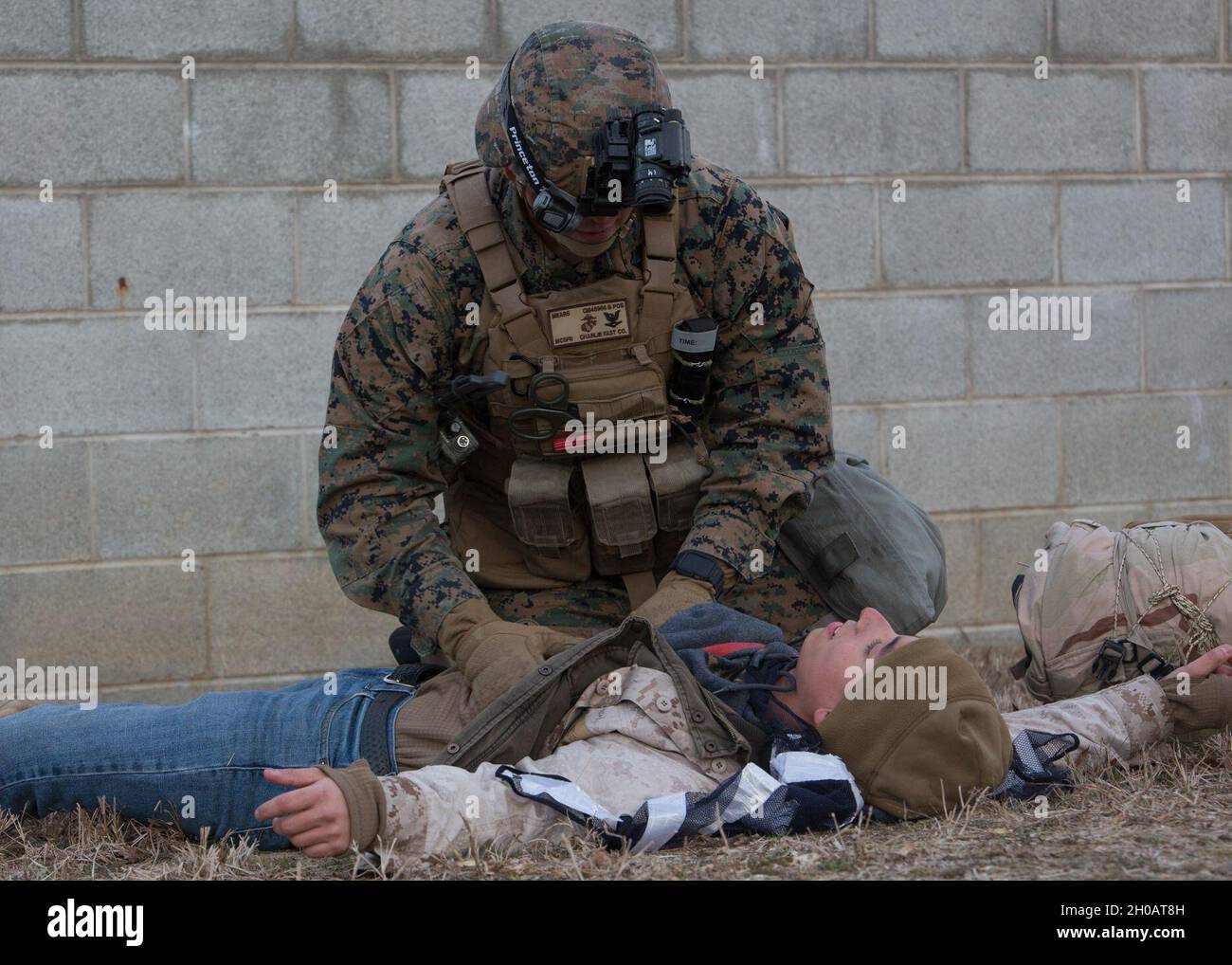 U.S. Navy Petty Officer 3rd Class Robert Mears, a corpsman with Charlie FAST Company, 5th Platoon, Marine Corps Security Force Regiment applies first aid to a notional gunshot wound during a Mission Readiness Exercise (MRX) Jan 13, 2021, on Fort A. P. Hill in Port Royal, Virginia. Fleet Antiterrorism Security Team (FAST) platoons execute MRX exercises prior to deployment to evaluate the platoons’ proficiency in core mission essential tasks. Stock Photo