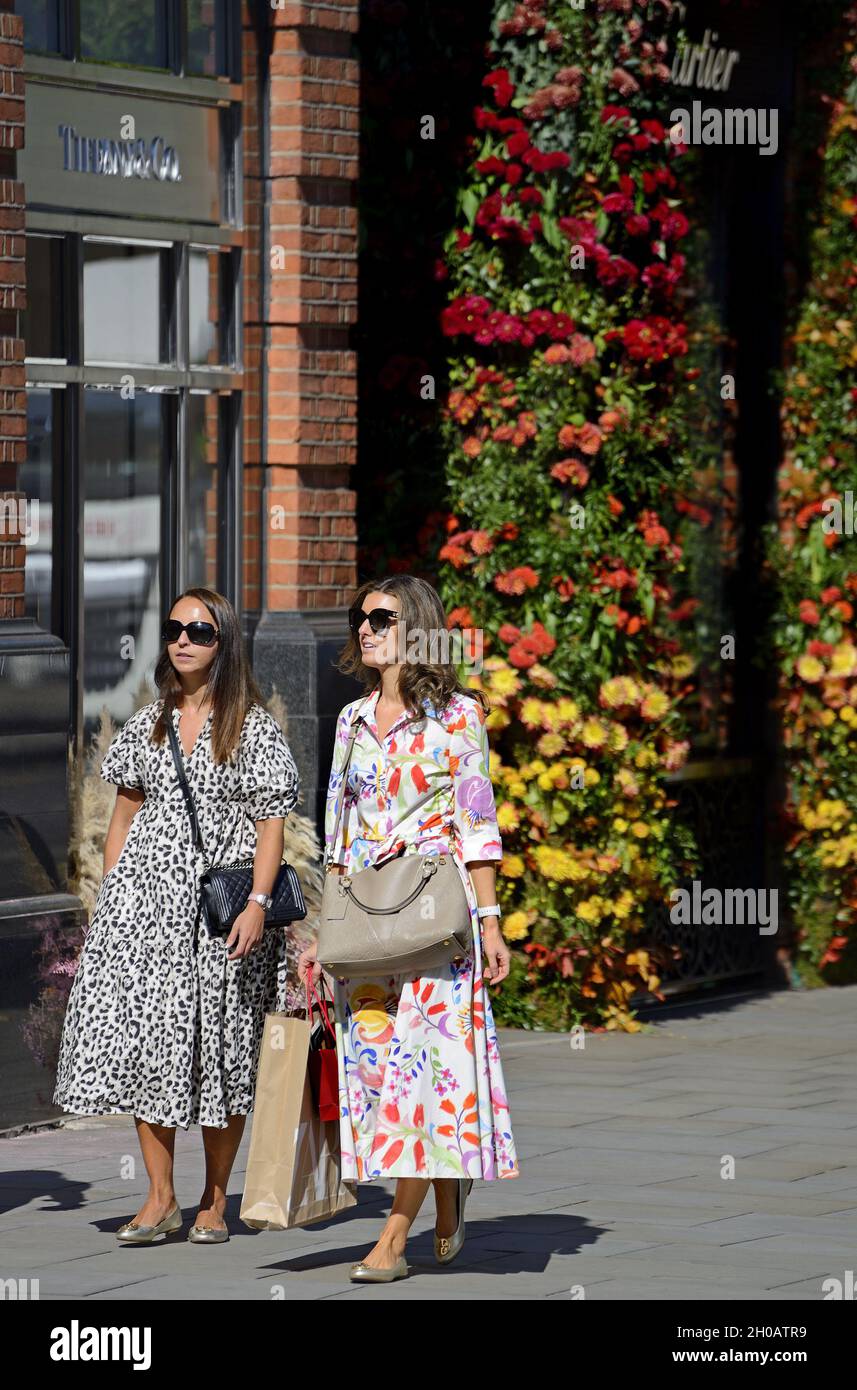 Women walking past Tiffany and Co in Sloane Square during Chelsea in Bloom annual floral art show and flower shower in the shops and streets of Chelse Stock Photo