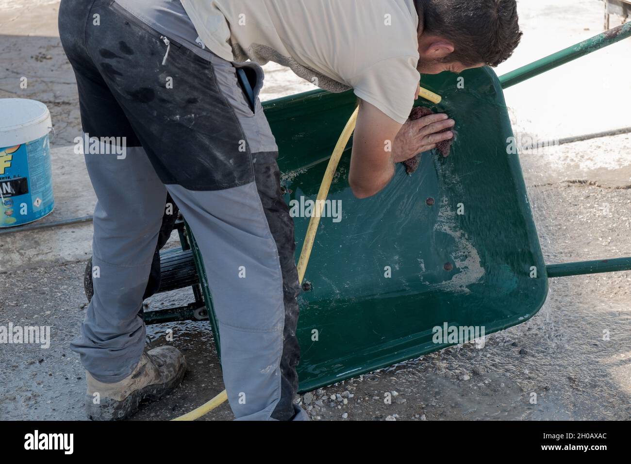 young worker cleaning forklift after a day's work. Stock Photo