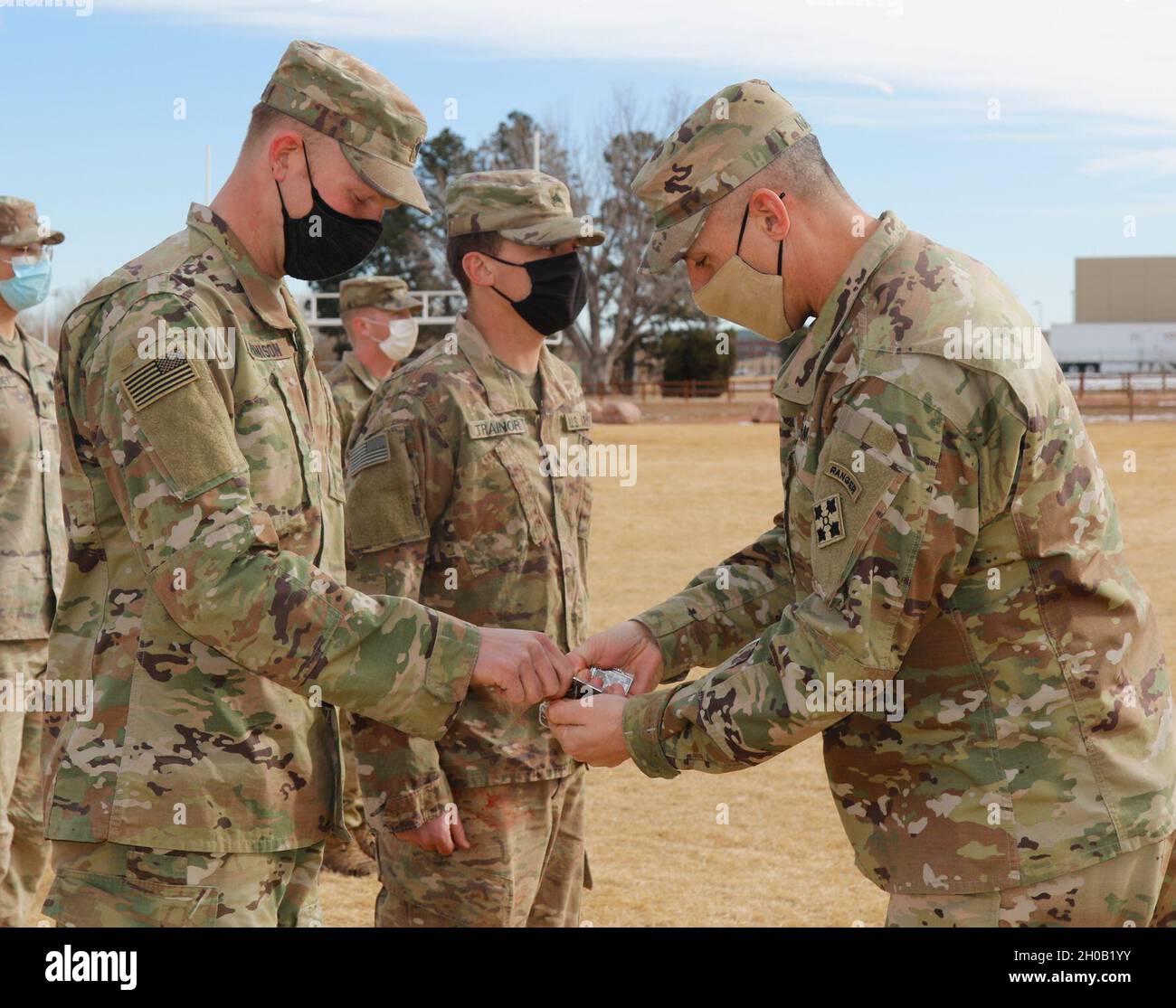 Command Sgt. Maj. Adam Nash (Right), Command Sgt. Maj. of the 4th Infantry Division, hands the winners of the Ivy Best Medic competition, Spc. Anchor Jennison (Left) with the 3-61 Cavalry Regiment, 2nd Stryker Brigade Combat Team, 4th Inf. Div. and Sgt. Tyrel Trainor (Center) with the 52nd Brigade Engineer Battalion, 2SBCT, 4th Inf. Div., the first place medal for the Ivy Best Medic competition Jan. 14, 2021 Fort Carson, Colorado. Ivy shaped medals were given to both winners of the Ivy Best Medic Competition. Stock Photo