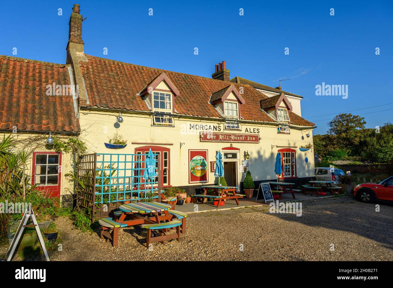 The front of The Hill House Inn pub glowing in the late afternoon sunshine in Happisburgh, Norfolk, England. Stock Photo