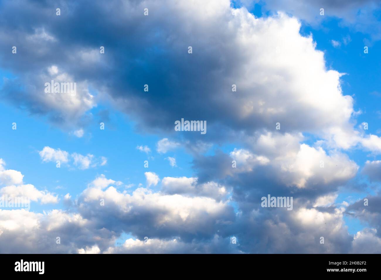 Gray storm clouds gather in the blue sky on a summer day. Several ...