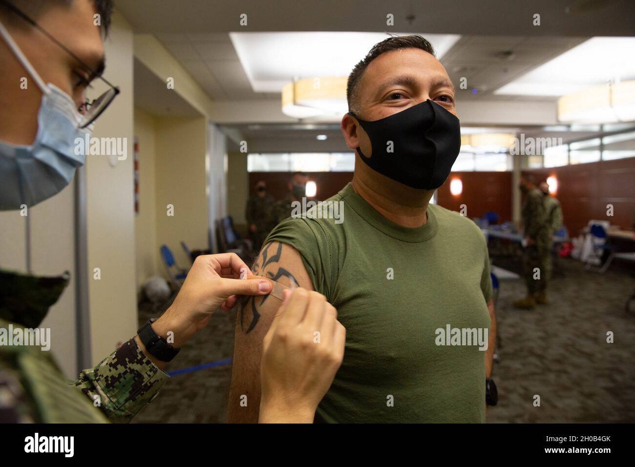 U.S. Marine Corps Master Gunnery Sgt. David Marinelarena, a field artillery chief with Headquarters Battery, 11th Marine Regiment, 1st Marine Division, receives the COVID-19 vaccination on Marine Corps Base Camp Pendleton, California, Jan. 15, 2021. The vaccine will help protect service members against COVID-19 and maintain medical readiness throughout 1st Marine Division. Stock Photo
