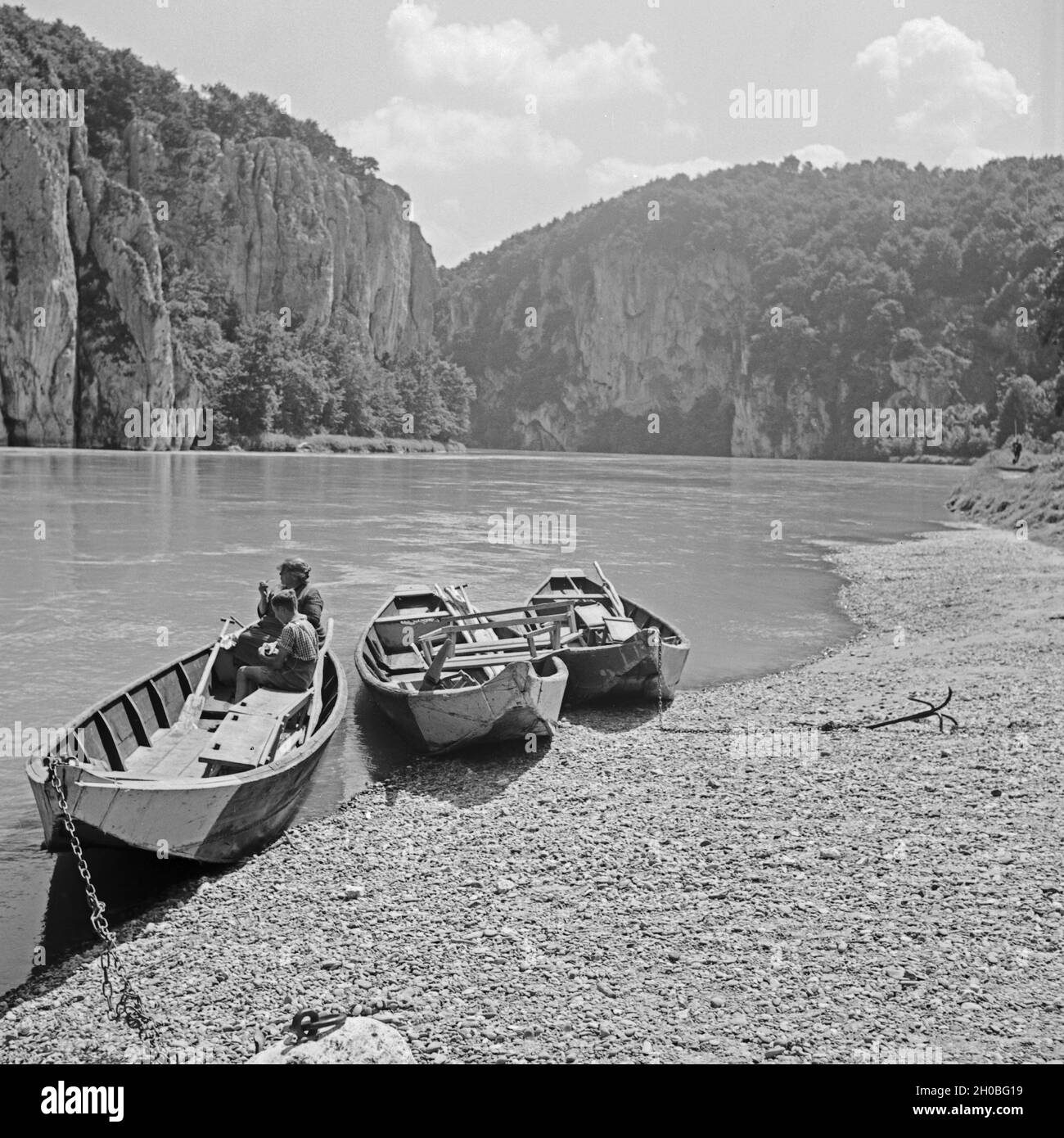 Ruderboote auf der Donau vor dem Kloster Weltenburg, Deutschland 1930er Jahre. Rowing boats on the shore of river Danube at Weltenurg Abbey, Germany 1930s. Stock Photo