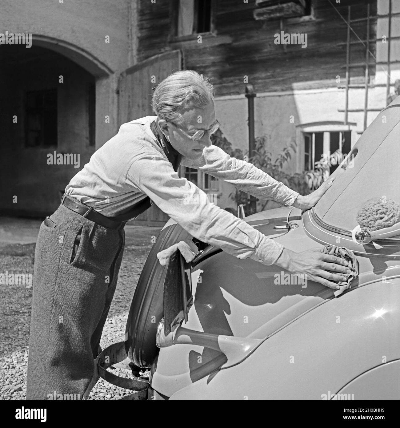 Ein Mann beim Wagenwaschen, Deutschland 1930er Jahre. A man washing a car, Germany 1930s. Stock Photo