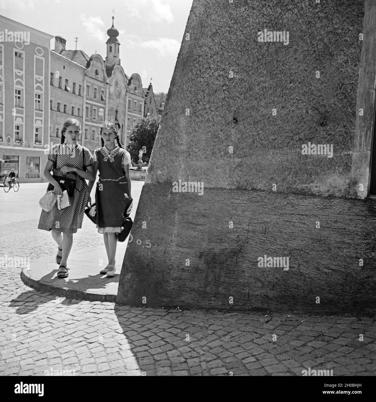Zwei Schulmädchen auf dem Weg nach Hause durch Burghausen, Deutschland 1930er Jahre. Two schoolgirls on their way home from school through the streets of Burghausen, Germany 1930s. Stock Photo
