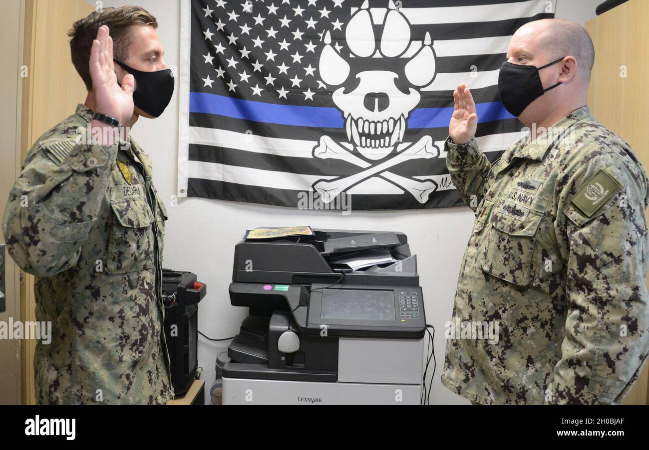 210119-N-AZ866-0014 NAVAL SUPPORT ACTIVITY SOUDA BAY, Greece (Jan. 19, 2021) Master-at-Arms 1st Class Michael Decarli recites the Oath of Reenlistment from Ensign Christopher Gibbs, security officer, during his reenlistment ceremony at the military working dog kennel onboard Naval Support Activity Souda Bay, Greece, Jan. 19, 2021. Decalri, a native of Evansville, Ind., has been the Navy for 9 years and at NSA Souda Bay for 3 months. He reenlisted for four more years.     Decarli is the Security Department’s kennel master and military working dog division leading petty officer, managing the exp Stock Photo