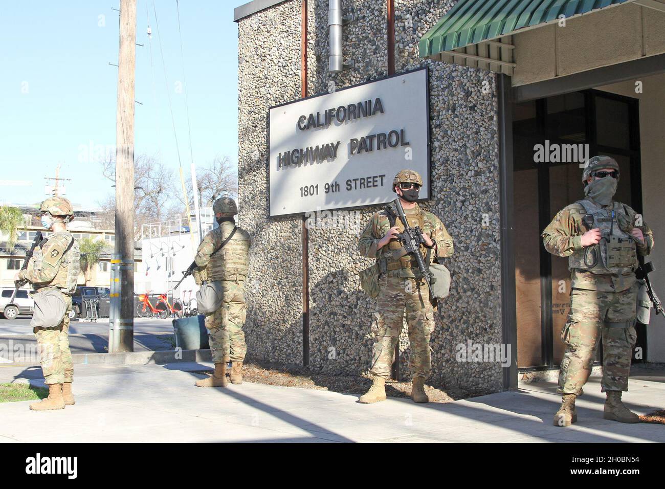 A California Army National Guard team of “Bridge Builders” — members of the 132nd Multirole Bridge Company, 579th Engineer Battalion, 49th Military Police Brigade — provide security at the California Highway Patrol office near the Capitol in Sacramento, California, Jan. 20, 2021. Cal Guard engineers are also on special assignment, joining infantrymen, military police and field artillerymen as the main force surrounding the state capitol during the inauguration of President Biden. The engineers shown: Spc. Kaylie Little, Pfc. Morgan Fults, Staff Sgt. Rusty Chambers and Pfc. Dylan Eagles. The 13 Stock Photo