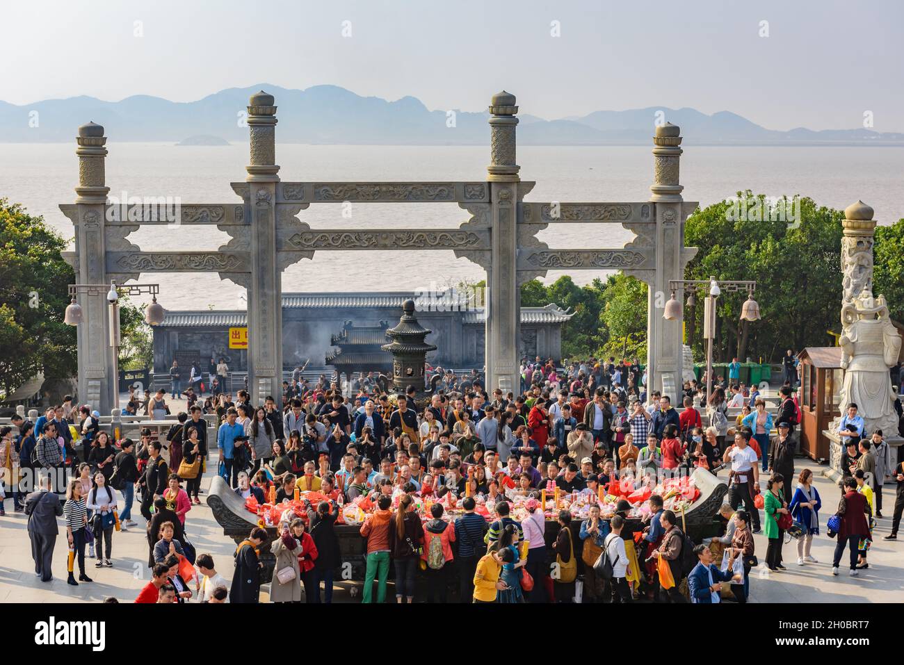 Zhejiang, China - 03 November 2017: Tourists giving prayers to Guan Yin Buddha statue. Stock Photo