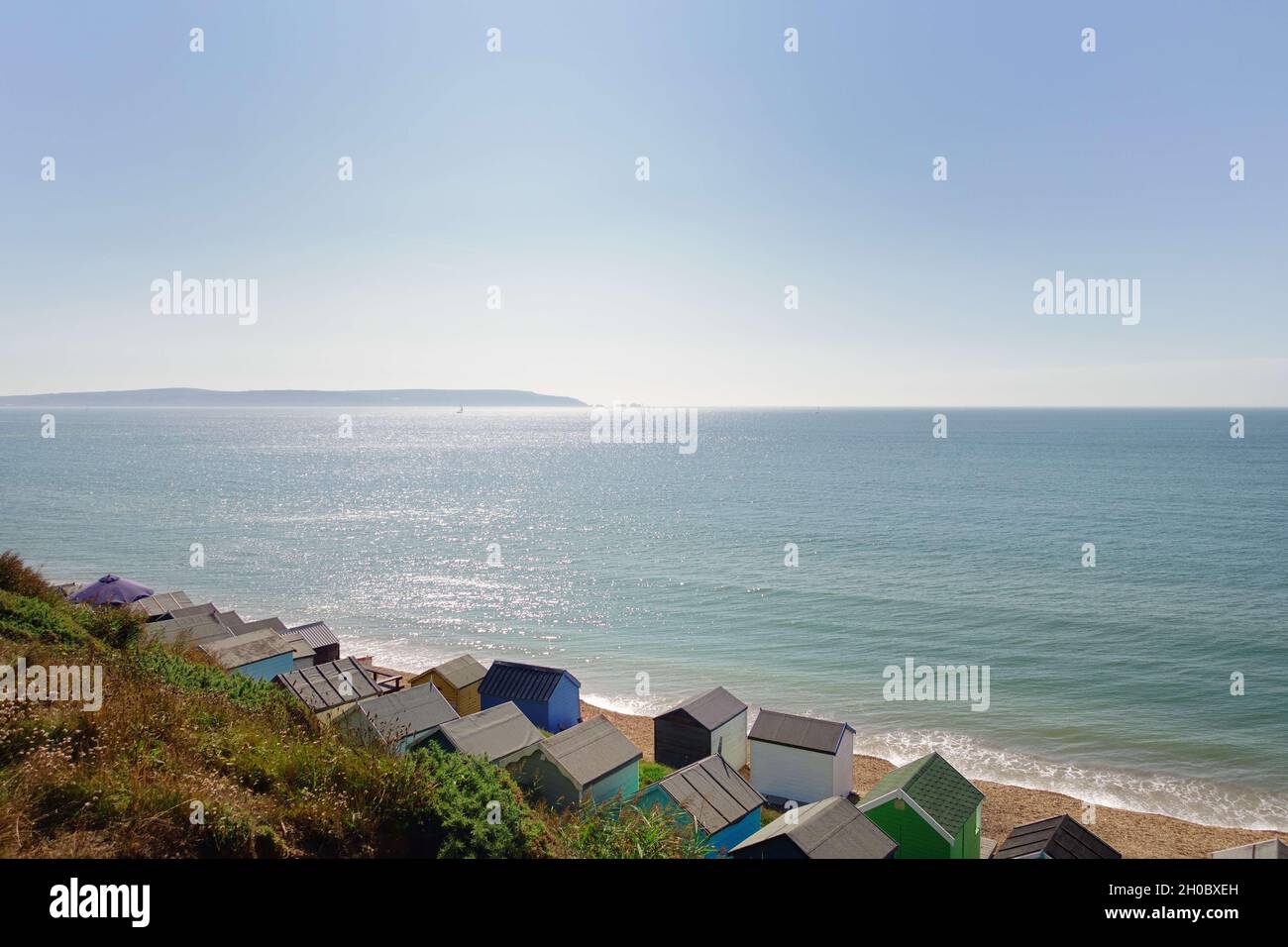 Beach huts on Hordle cliff beach with the Isle of Wight in the background Stock Photo